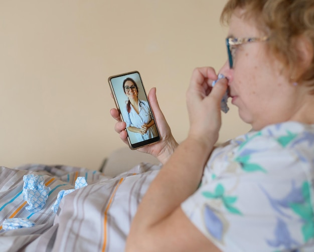 Foto una anciana está enferma de coronavirus una mujer con una enfermedad respiratoria viral está en cuarentena y consulta a un médico en línea