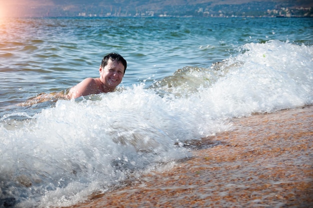 Una anciana está nadando en el mar sobre las olas Día soleado de verano