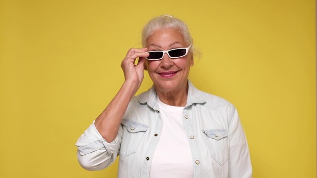 Foto una anciana europea con anteojos mira con confianza a la cámara sonriendo