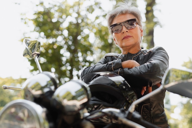 Anciana fresca de ángulo bajo con motocicleta