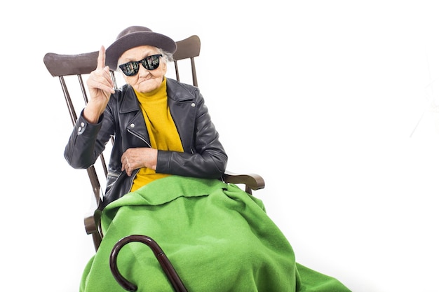 Anciana con gafas de sol sentada en una silla