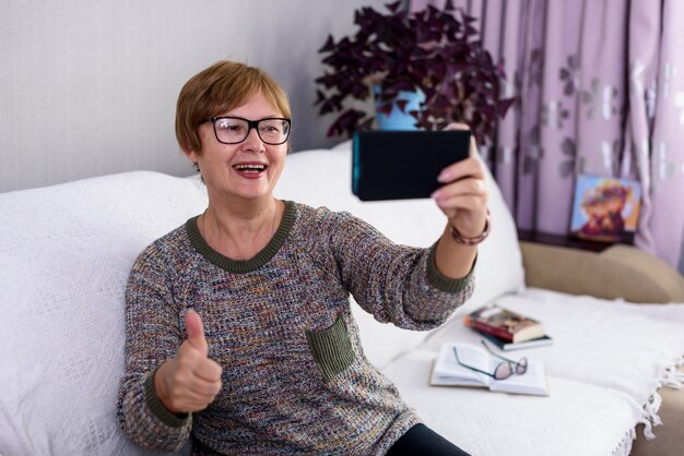 Foto una anciana habla en video desde su casa y dice que todo estará bien.