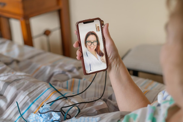 Una anciana hablando con el médico por teléfono Un jubilado sufre una enfermedad respiratoria y hace una videollamada al terapeuta Consulta en línea