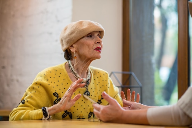 Anciana hablando en la mesa