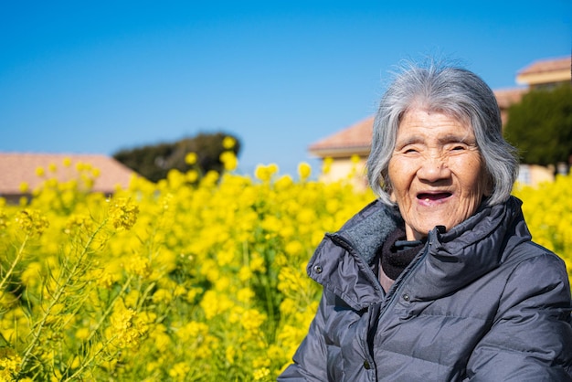 Una anciana japonesa sonriente y un jardín de flores