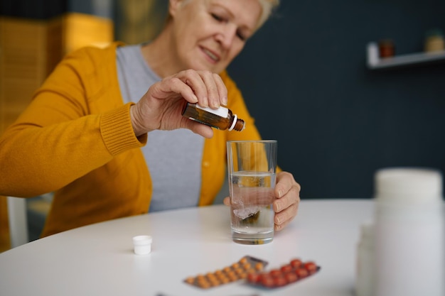 Anciana jubilada goteando gotas sedantes médicas