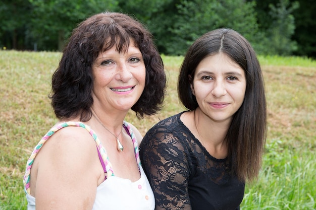 Foto una anciana jubilada con una hija de 30 años se sienta en el banco del parque