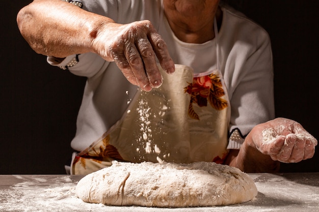 Anciana, manos de la abuela Preparar pan casero tradicional. Ciérrese encima de la vista de la masa de amasamiento del panadero. lugar de receta de menú para texto