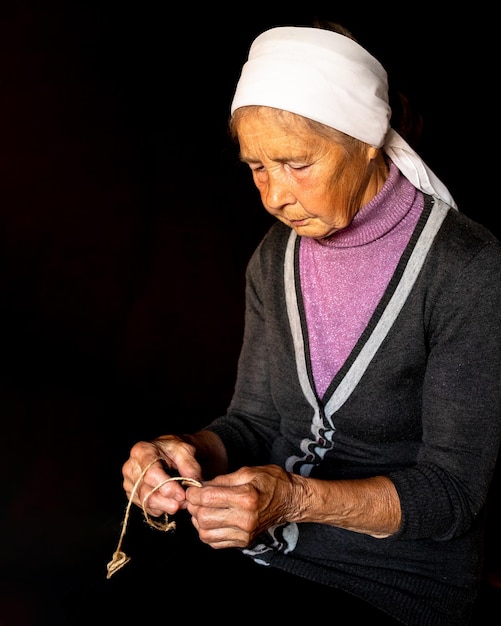 Foto anciana manos de anciana con enfermedad de poliartritis cuerdas de lienzo en los dedos de anciana marionetas