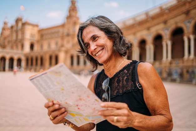 Anciana en el mapa para decidir qué visitar en la ciudad Mujer mayor viajando por Europa