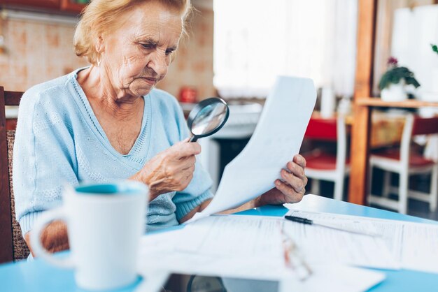 Foto anciana mirando sus facturas de servicios públicos