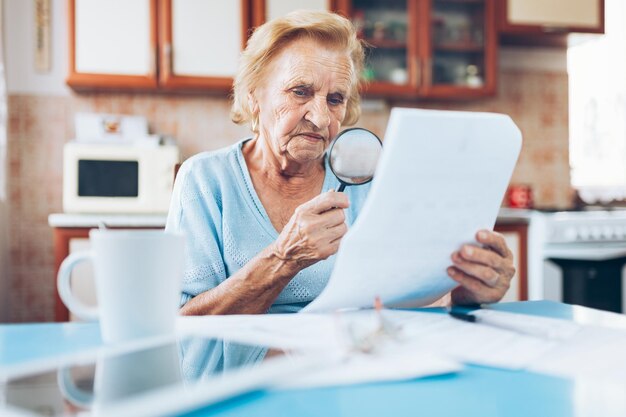 Foto anciana mirando sus facturas de servicios públicos