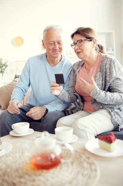 Anciana mostrando fotografías antiguas a marido