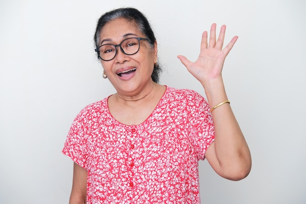 Anciana mujer asiática agitando su mano para saludar a alguien