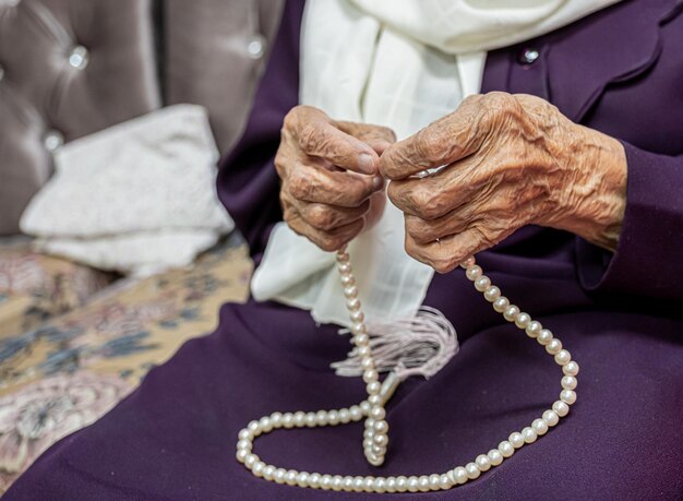 Anciana musulmana y su nieta usando rosario y orando por Dios