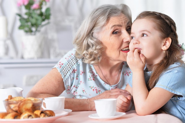 Anciana con una niña bebiendo té