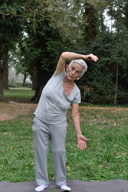 Foto anciana practicando yoga al aire libre