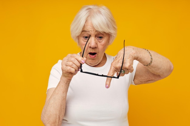 Anciana problemas de visión con gafas de fondo amarillo