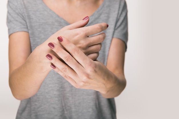 Foto anciana que sufre de dolor, debilidad y hormigueo en la muñeca. las causas del dolor incluyen osteoartritis, artritis reumatoide, gota o esguince de muñeca. concepto de cuidado de la salud