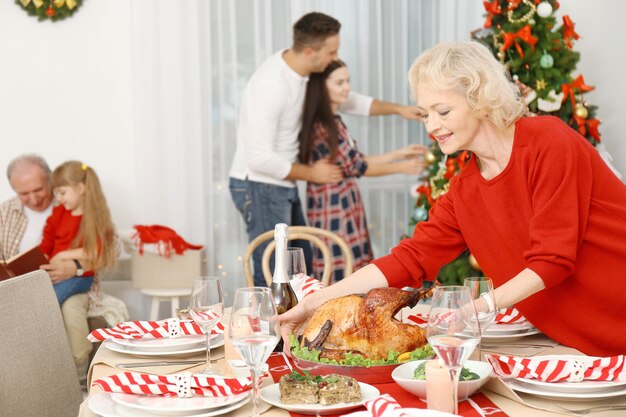 Anciana sirviendo mesa para la cena de Navidad