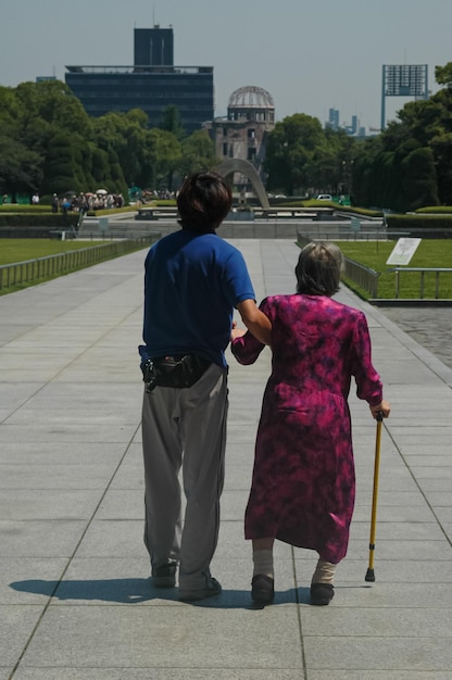 una anciana sobreviviente de la bomba de hiroshima camina con su nieto en el lugar de la explosión