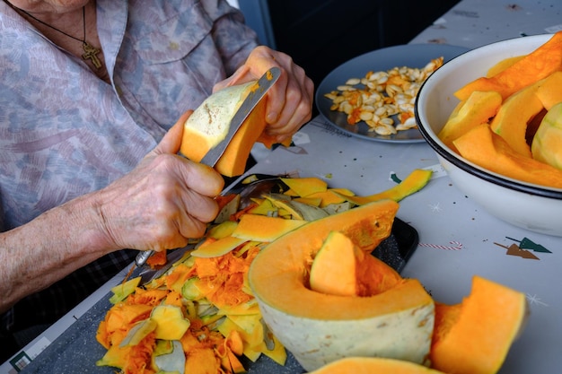 Anciana solitaria cortes y pastillas calabaza amarilla cocinar sopa de calabaza vida de retiro enfoque selectivo