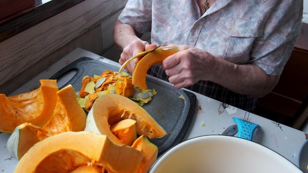 Foto anciana solitaria cortes y pastillas calabaza amarilla cocinar sopa de calabaza vida de retiro enfoque selectivo