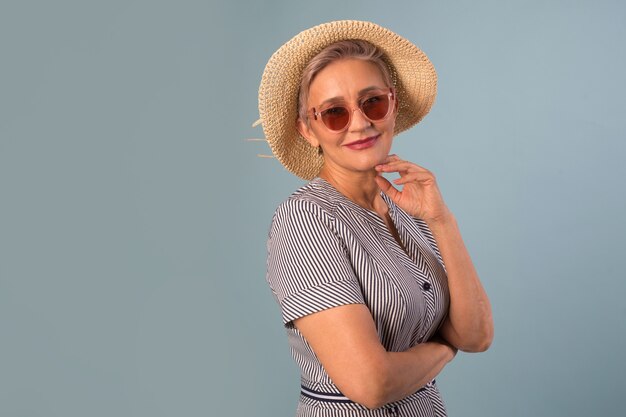 Anciana con un sombrero sobre un fondo azul.