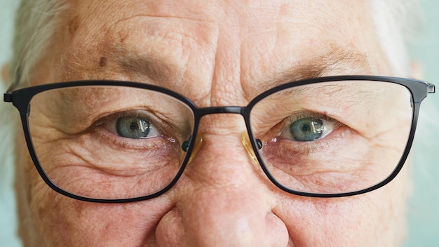 Anciana sonriente positiva con gafas mirando a la cámara