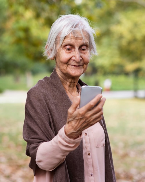Anciana sosteniendo un teléfono inteligente