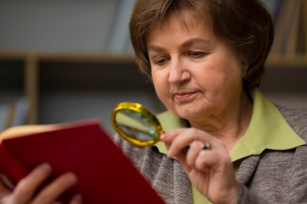 Foto anciana de tiro medio leyendo en casa