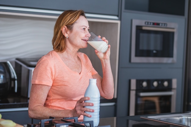 Anciana tomando un vaso de leche por la mañana.