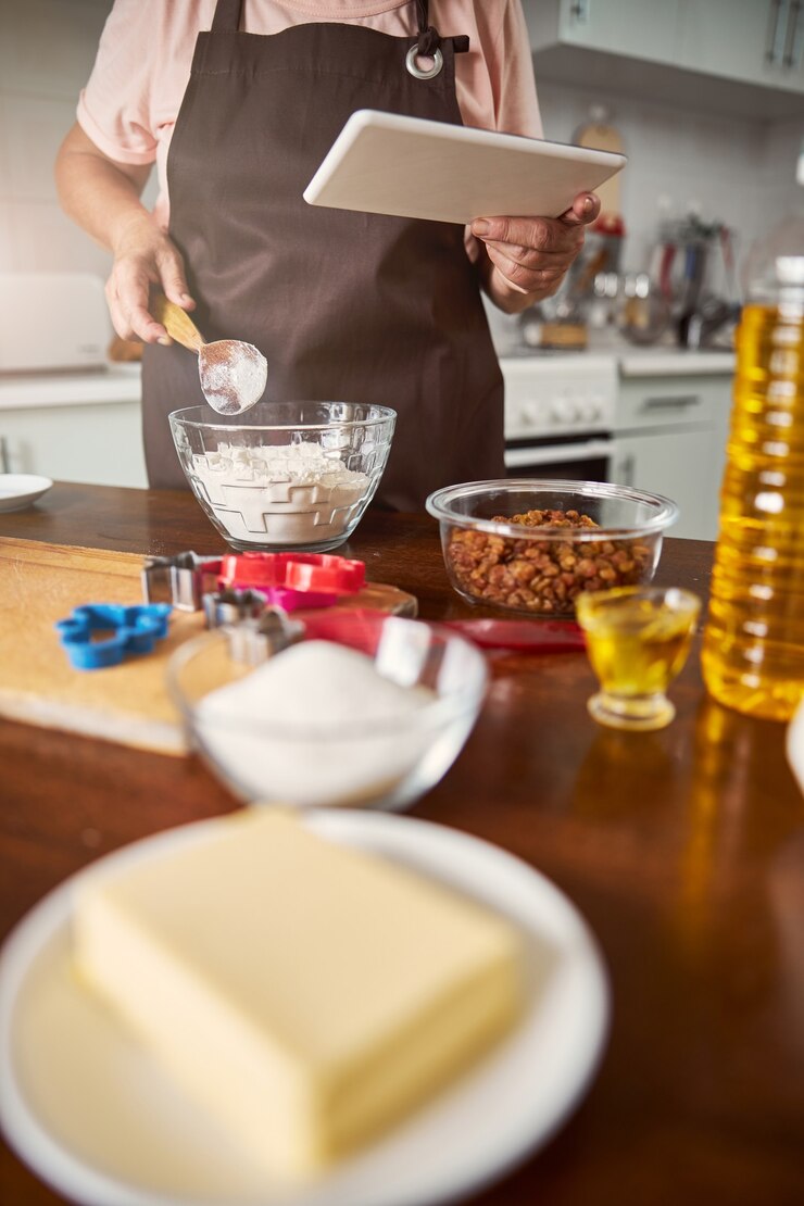 Foto anciana trabajadora comprobando la receta en línea antes de cocinar