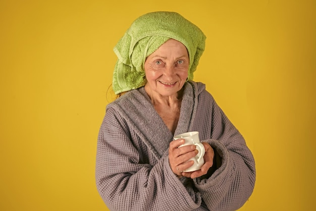 Anciana en turbante de toalla con copa.