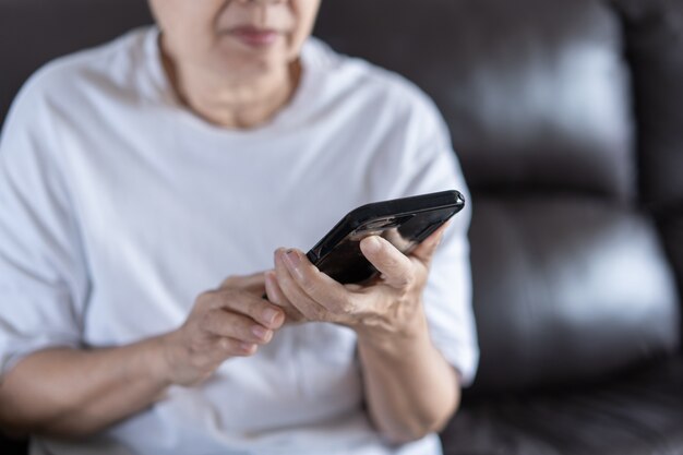 Anciana usando su teléfono en casa