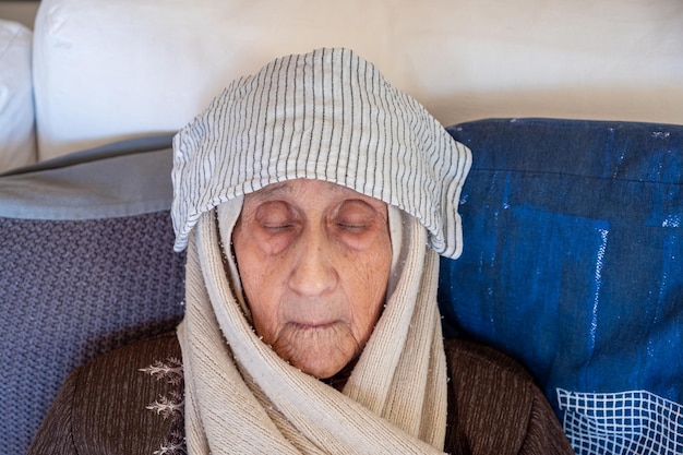 Foto una anciana usando una toalla húmeda para detener el dolor de cabeza y la alta temperatura corporal