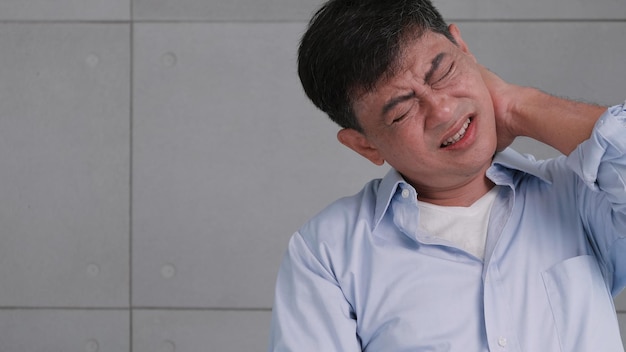 Foto anciano asiático con dolor de cuello