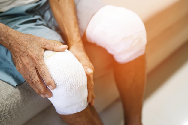 Un anciano asiático tiene dolor en la rodilla y problemas óseos.