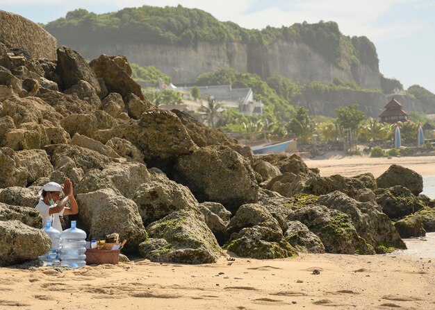 Un anciano balinés rezando en la playa.