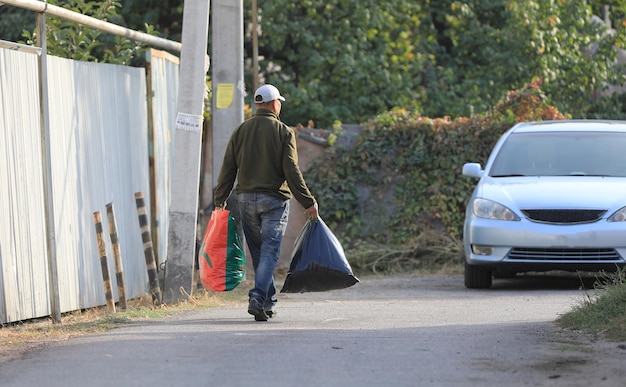 anciano con bolsas en la calle