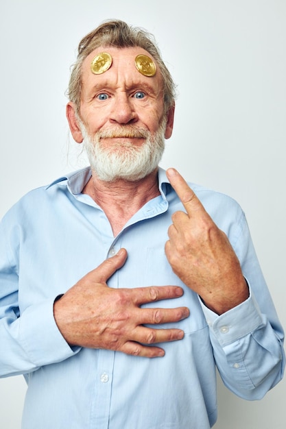 Anciano en una camisa azul bitcoins en la cara de fondo aislado