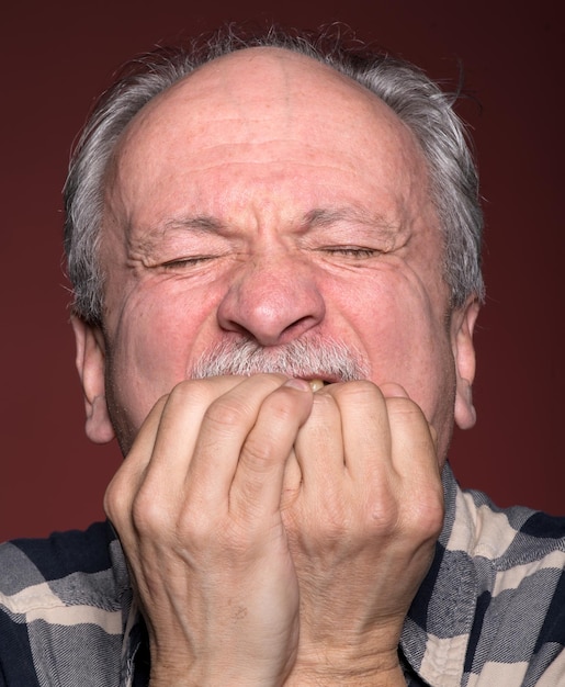 Anciano con la cara cerrada por las manos