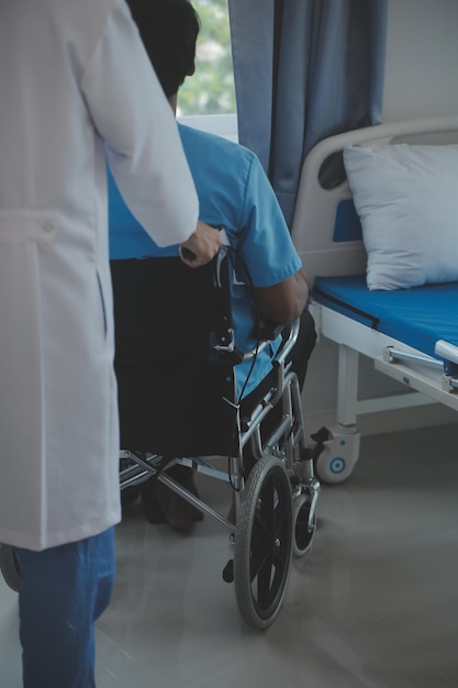 Un anciano deprimido sentado solo en la cama del hospital por la noche se siente solo y abandonado