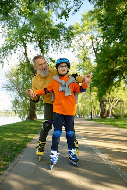Anciano disfrutando de los deportes en el soleado parque de verano con su pequeño hijo