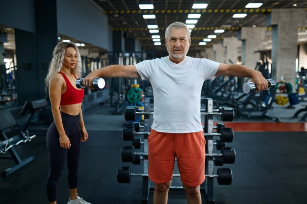 Anciano, ejercicio con pesas, entrenadora