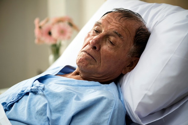 Un anciano enfermo se hospeda en el hospital.