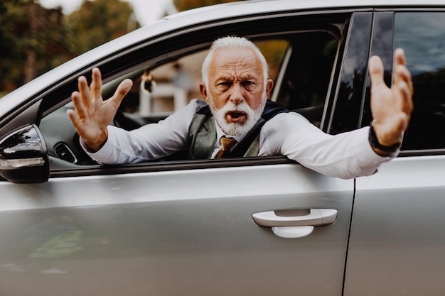 Un anciano enojado discutiendo después de un accidente automovilístico.