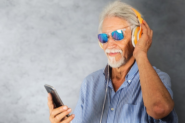 Anciano escucha música con auriculares