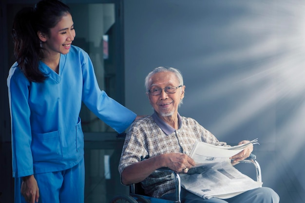 Anciano feliz hablando con su enfermera en el hospital