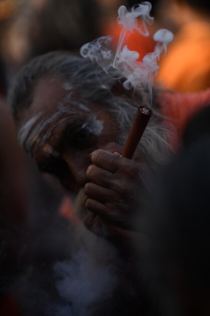 El anciano fumando fumando chillum sadhu fumando en la India kumbh mela